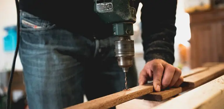 Mann baut einen Kratzbaum und bohrt Holz